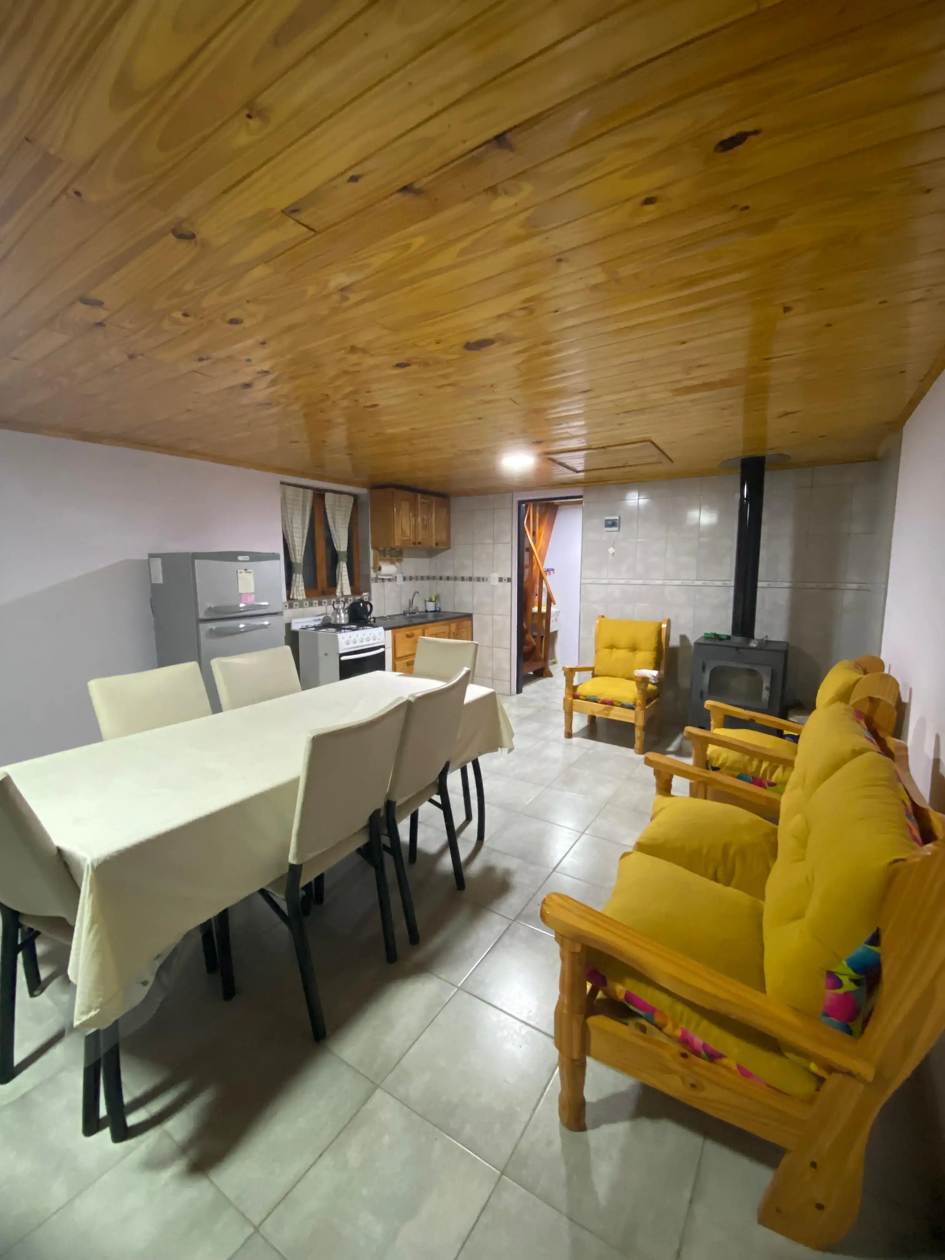 Interior de Cabaña Andesita vista a la cocina, mesa para comer y sillones