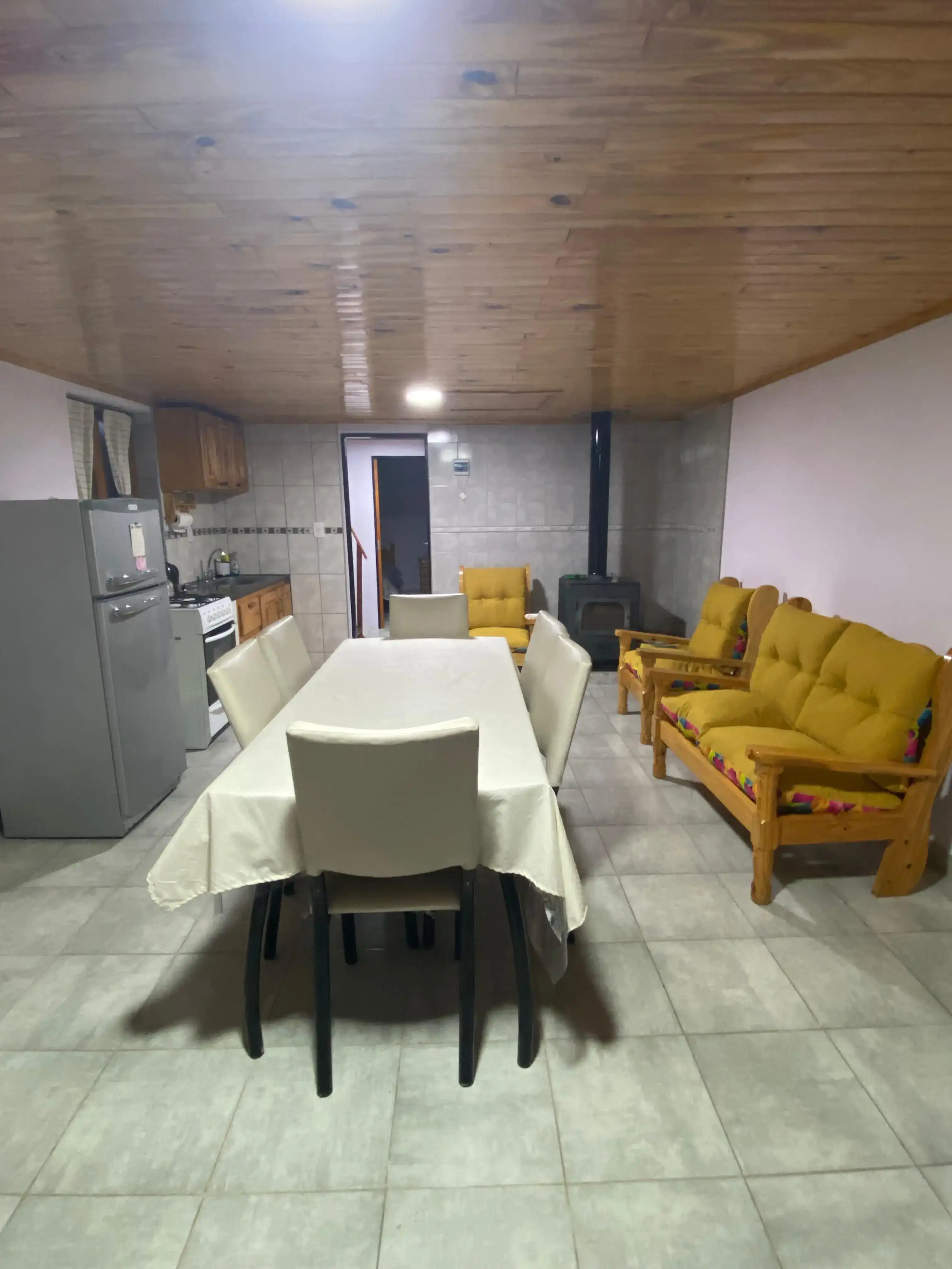 Interior de Cabaña Andesita vista a la cocina, y mesa para comer y sillones